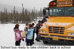 Children standing next to the school bus